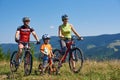 Verkhovyna, Ukraine - August 19, 2017: tourist family, mom, dad and boy with mountain bicycles on mountain grassy valley