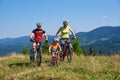 Verkhovyna, Ukraine - August 19, 2017: Tourist bikers, mom, dad and small child boy cycling mountain bicycles down hill