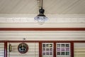 A verly large traditional light bulb and clock with window on a train platfrom