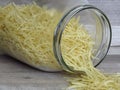 Vermicelli in a glass jar. Close up view. Spilled vermicelli.