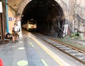 Vernazza, Liguria, Italy. June 2021. The railway station is adjacent to the tunnel exit. The train is coming, the travelers are Royalty Free Stock Photo