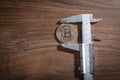 Vernier caliper and Bitcoin on the wooden table