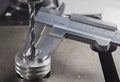 Vernier caliper measures metal drill bit, make holes in steel billet on industrial drilling machine. Metal work industry