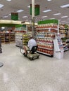 A disabled senior citizen shopping in the grocery store riding a scooter Royalty Free Stock Photo