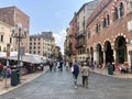 Verona, Italy - August 31, 2019: People walking along the market street, old european houses on Piazza delle Erbe Royalty Free Stock Photo
