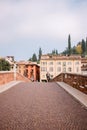 Cyclist crossing the ancient Roman bridge Ponte Pietra in Verona, Veneto