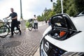 Verona, italy - september 20, 2021: An electric car recharges its batteries on a public street in front of people on bicycles