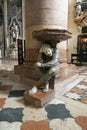 VERONA, VENETO, ITALY - February 15, 2019 Reflecting man stone statue supporting a fount with his back inside catholic church