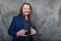 Versatile man with long hair in a sharp blue suit showcasing different standing postures