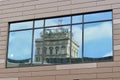 Distorted reflection of skyscraper in office window.