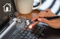 On the versual screen, the woman's hand is pointing to a keyboard and the home symbol. The notion of home loan payment Royalty Free Stock Photo