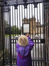 Vertical of an adult woman reading about Queen's death on the gates of Palace of Holyroodhouse Royalty Free Stock Photo