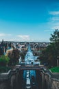 Vertical aerial shot of cars on a street with buildings and trees in a city under a blue sky Royalty Free Stock Photo