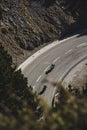 Vertical aerial shot of two motorcyclists riding on a mountain road in the Pyrenees