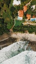 Vertical aerial top view of a private exotic resort near the shore in Playa Negra, Costa Rica