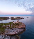 Vertical aerial view of a building at the edge of a rocky coast at a sunset Royalty Free Stock Photo