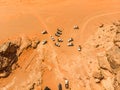 Vertical aerial view of a pack of off-road vehicles with tourists in the Wadi Rum desert in Jordan, taken with drone Royalty Free Stock Photo