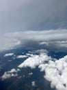 Vertical aerial view of a rural landscape enveloped in puffy clouds in blue sky background Royalty Free Stock Photo