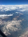 Vertical aerial view of a rural landscape enveloped in puffy clouds in blue sky background Royalty Free Stock Photo