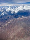 Vertical aerial view of a rural landscape enveloped in puffy clouds in blue sky background Royalty Free Stock Photo