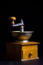 Vertical of an antique coffee grinder machine captured against a dark background