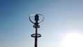 Vertical axis wind turbine utilize renewable wind energy while spinning against blue sky