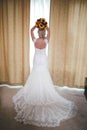 Vertical back view of a bride holding a bouquet over her head before throwing it Royalty Free Stock Photo