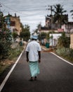 Vertical back view of an Indian male walking in the streets of Karaikudi, Tamil Nadu, India