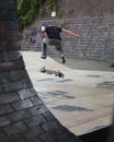 Vertical back view of a male skateboarder making tricks in a park