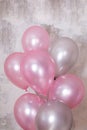 Vertical banner with bunch of silver and pink baloons on gray concrete background