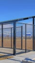 Vertical Baseball field dugout with slanted roof and chain link fence on a sunny day