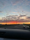 Vertical of a beautiful sunset seen through the windshield of a car driving on the highway Royalty Free Stock Photo