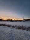 Vertical beautiful winter landscape of snow covered field near parking spot at sunset Royalty Free Stock Photo