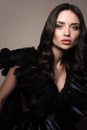 Vertical beauty-portrait of beautiful young woman in black. Clothes made of black feathers