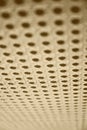 Vertical beige perforated surface of audio textile material