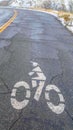 Vertical Bicycle lane symbol on a weathered road in winter