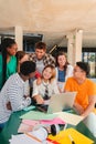 Vertical. Big group of real teenage students searching information using a laptop at university campus library Royalty Free Stock Photo