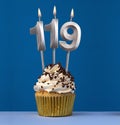 Vertical birthday card with cake - Lit candle number 119 on blue background Royalty Free Stock Photo