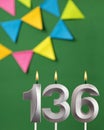 Vertical birthday card with number 136 candle - Green background with pennants