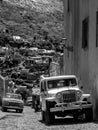 Vertical black and white shot of cars on a road in Real de Catorce, Mexico