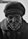 Vertical black and white shot of an old African woman with wrinkled face