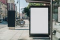 Vertical blank billboard at bus stop on city street. In background buildings, road. Mock up. Poster next to roadway. Royalty Free Stock Photo