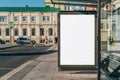 Vertical blank billboard at bus stop on city street. In background buildings, road. Mock up. Poster next to roadway. Royalty Free Stock Photo