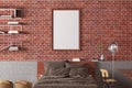 Vertical blank poster frame mock up on the red brick wall in interior of loft bedroom Royalty Free Stock Photo