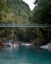 Vertical of Blue pools New Zealand with a rope bridge over the lake Royalty Free Stock Photo