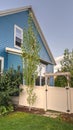 Vertical Blue timber clad house with neat fenced garden