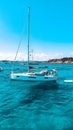 Vertical of a boat sailing in the blue waters of Sardinia Island, Italy Royalty Free Stock Photo