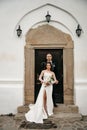 Vertical of a bride and groom posing in front of the church door Royalty Free Stock Photo