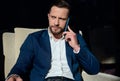 Vertical business portrait of an attractive handsome self-confident Caucasian businessman , entrepreneur talking on cellphone