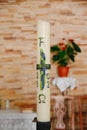 Vertical of a candle with Alpha and Omega symbols, a cross and the year 2022